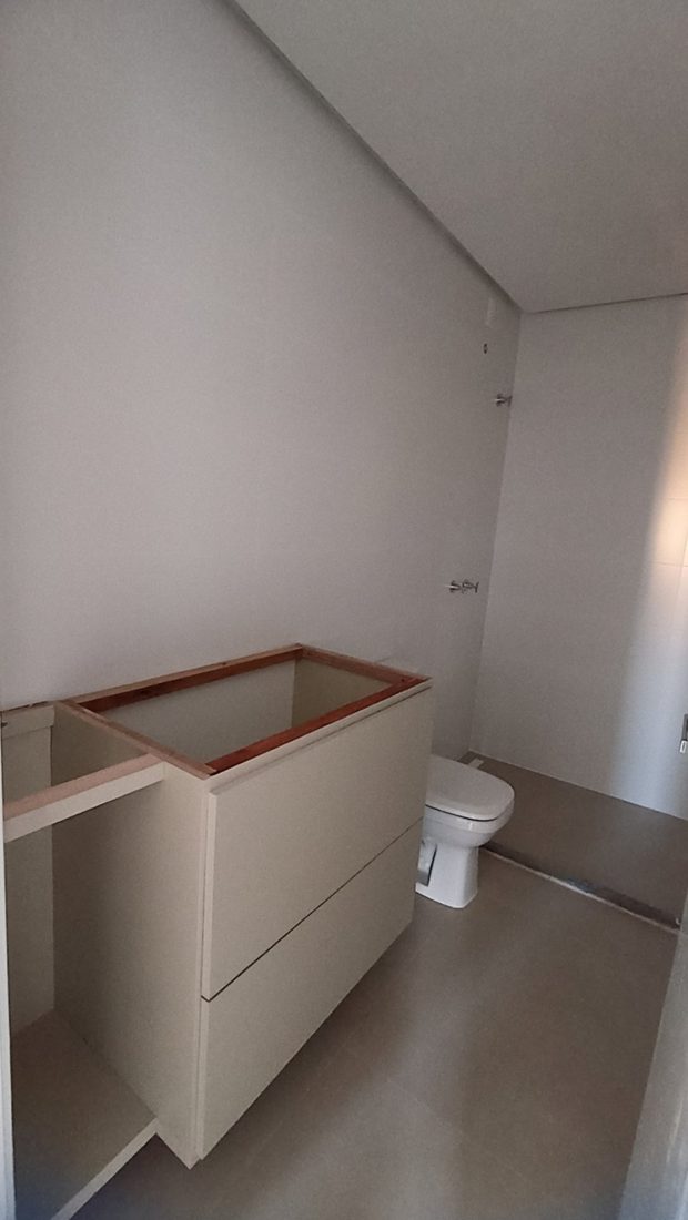 Antes: banheiro em obra, com gabinete sem tampo